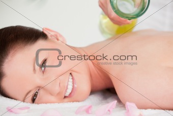Close up of a woman having massag oil versed on her back