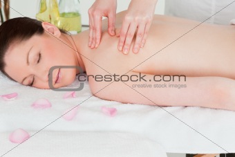 Young woman having a shoulder massage in a spa