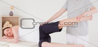 Sportswoman having a leg and hips stretching