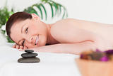 Young red-haired woman in a spa with a potpourri and massage sto
