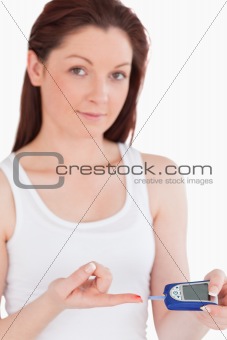 Cute woman testing her blood