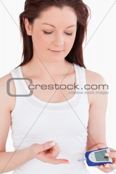 Cute woman using a blood glucose meter