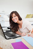 Young brunette woman relaxing with her laptop and posing while w