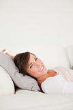 Cute brunette woman posing while lying on a sofa