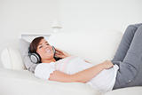Good looking brunette female relaxing with her headphones while 