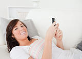 Attractive brunette female writing a text on her mobile
