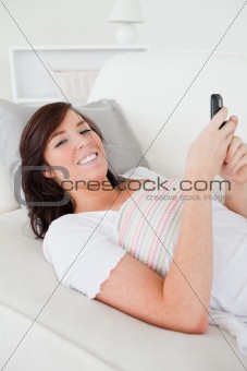 Beautiful brunette female writing a text on her mobile