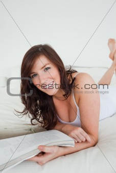 Beautiful female reading a magazine while lying