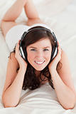 Good looking female with headphones lying