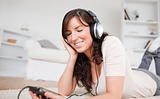 Cute brunette woman listening to music with her mp3 player while