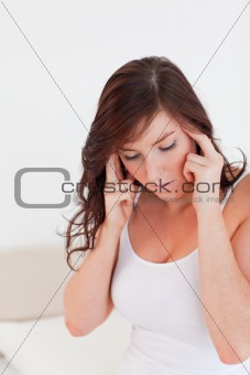 Beautiful brunette woman having a headache while sitting