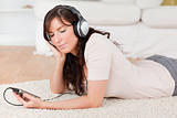 Charming brunette female listening to music with her mp3 player 