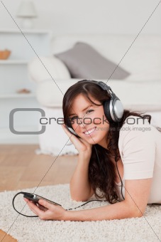 Beautiful brunette female listening to music with her mp3 player