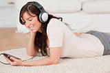 Gorgeous brunette female listening to music with her mp3 player 