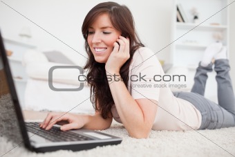 Attractive brunette woman on the phone while relaxing with her l