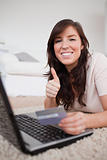 Young charming woman making a payment with a credit card on the 