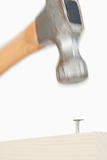 Close up of a hammer driving a nail