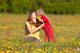 mother and son picking flowers at dandelion field in spring