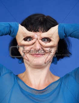 middle-aged woman making funny gesture - isolated on blue
