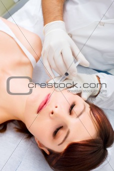 young caucasian woman receiving an injection of botox from a doctor