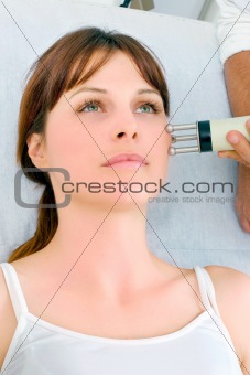portrait of a young caucasian woman receiving electrostimulation lifting