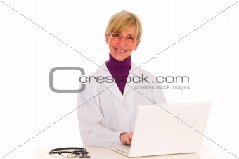 female doctor at the desk with stethoscope and laptop