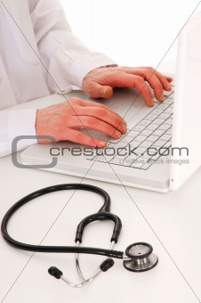 doctor at the desk with stethoscope and laptop
