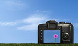 digital camera on grass against blue sky