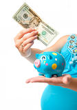pregnant woman with a piggy bank