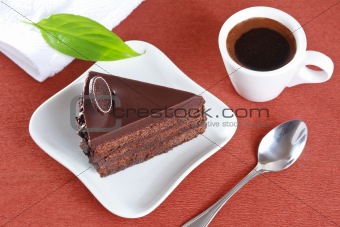 Chocolate cake and a cup of coffee on a brown background