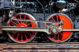 red wheels of an old steam locomotive standing on rail