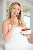 Pregnant woman with bowl of strawberries smiling