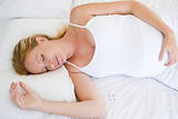 Pregnant woman lying in bed sleeping