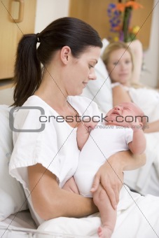 New mother with crying baby in hospital