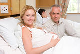 Pregnant woman with husband in hospital smiling