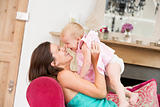 Pregnant mother in living room holding daughter and laughing