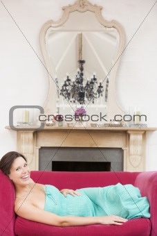 Pregnant woman lying in living room smiling