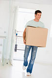 Man with box moving into new home smiling