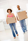 Couple with boxes moving into new home smiling