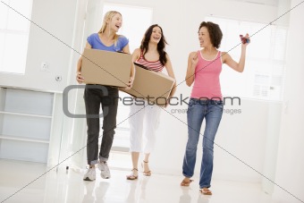 Three girl friends moving into new home smiling