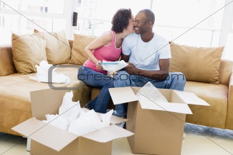 Couple unpacking boxes in new home kissing and smiling