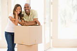 Couple with boxes in new home smiling
