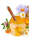 sweet honey in glass jars with spoon and flowers