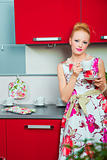 blond woman with cup of coffee in interior of kitchen