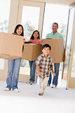 Family with boxes moving into new home smiling