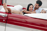 man and beautiful woman hugging in cabriolet car