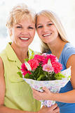 Granddaughter and grandmother holding flowers and smiling