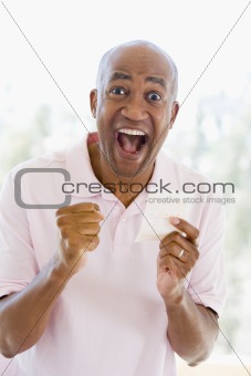 Man with winning lottery ticket excited and smiling