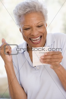 Woman with winning lottery ticket excited and smiling