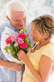 Husband giving wife flowers and smiling
